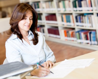 Female teacher grading exams at the library