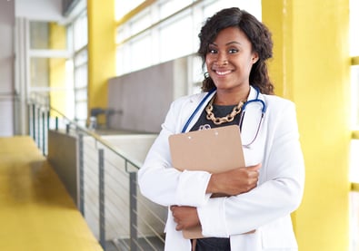 Portrait of a female doctor holding her patient chart in bright modern hospital