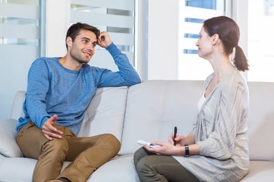 Psychologist talking with happy man in the office